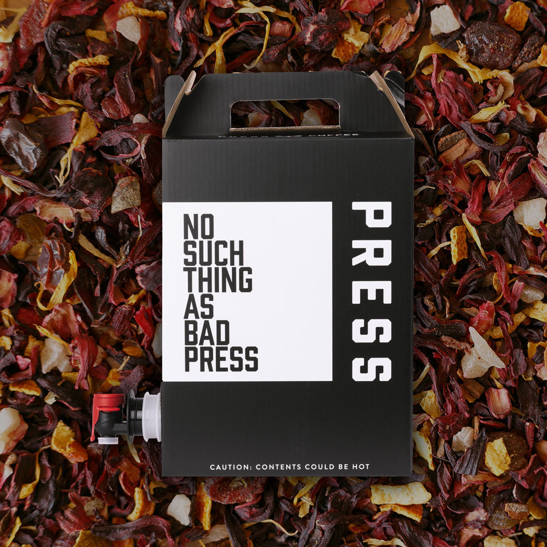 Black box with 'No Such Thing as Bad Press' text on a bed of colorful dried leaves.
