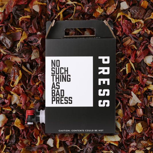 Black box with 'No Such Thing as Bad Press' text on a bed of colorful dried leaves.